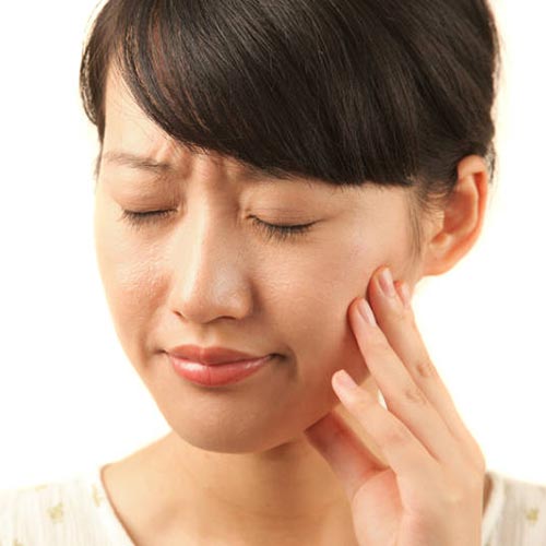 tooth extraction needed for woman with tooth pain holding mouth cheek